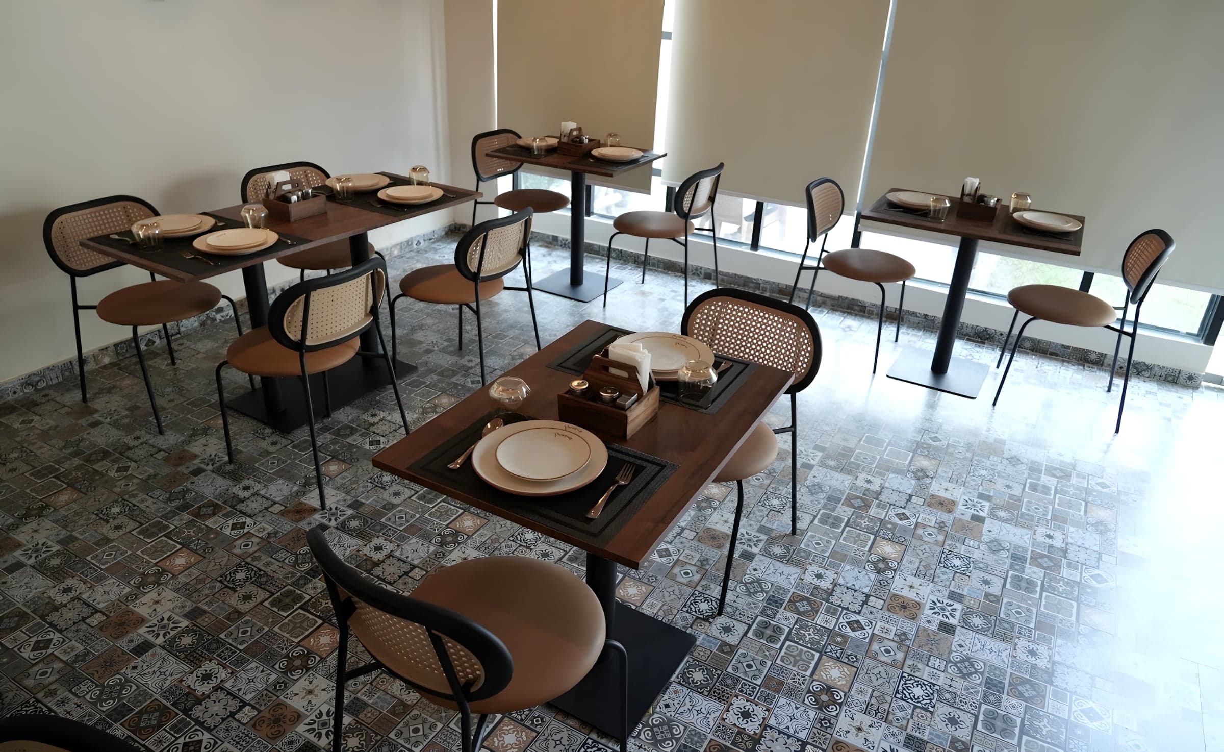 A table laid for two by the window, on patterned tiles