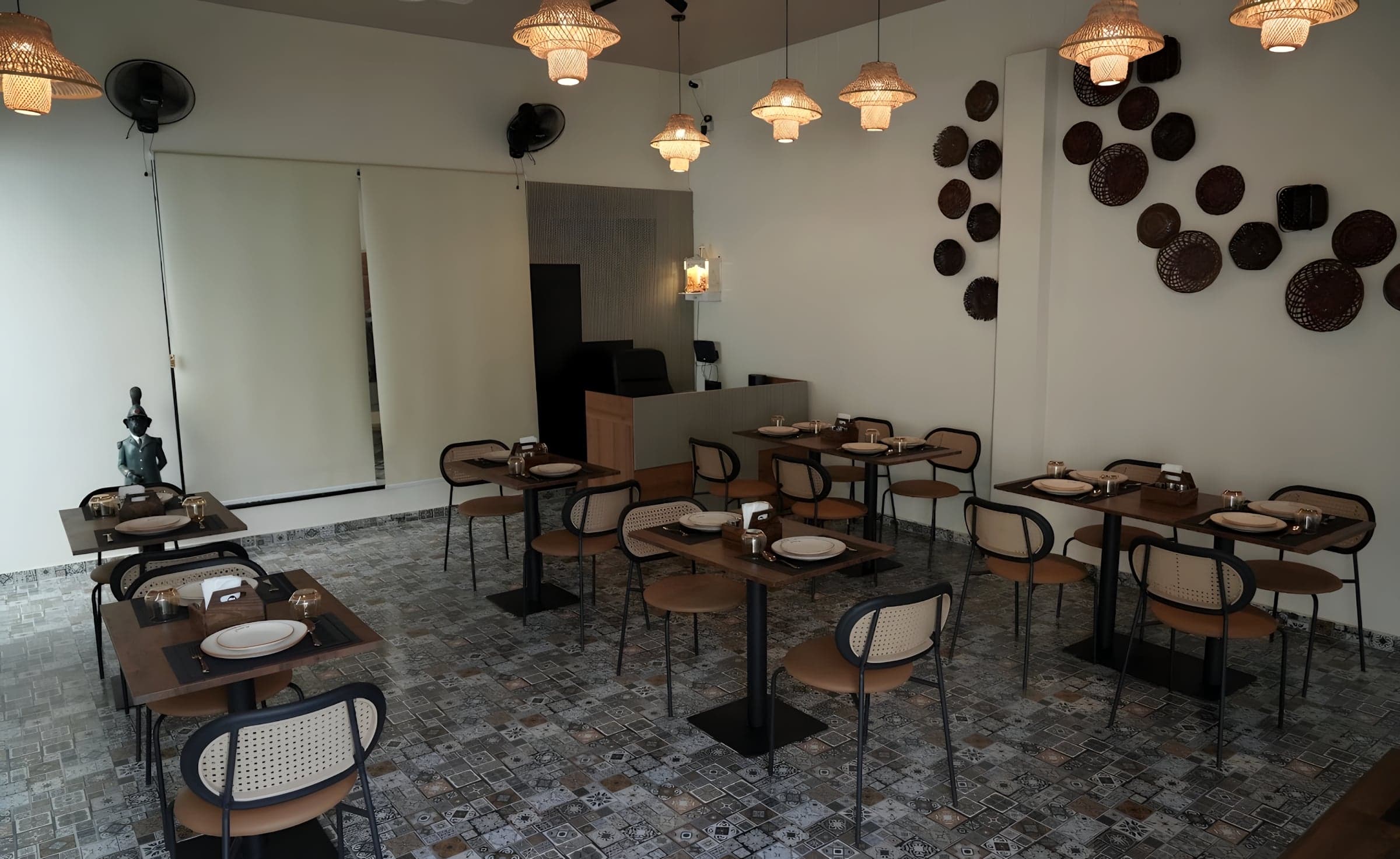 The café’s dining room with a wall of woven plates and pendant lamps